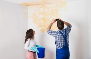 New homeowner and a painter look at a construction defect